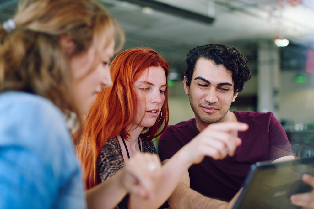 Unposed group of creative business people in an open concept office brainstorming their next project.-4.jpeg